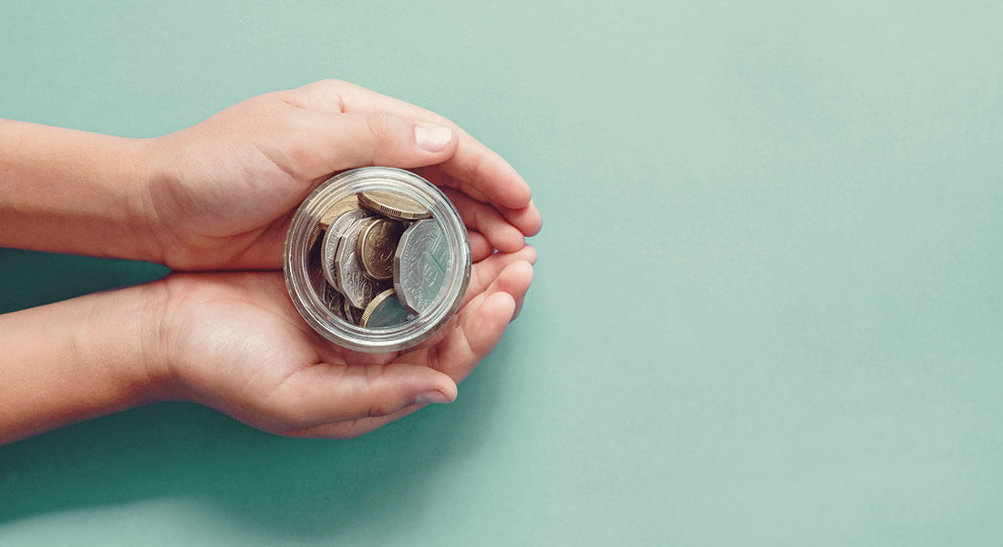 Hands holding donation coin jar